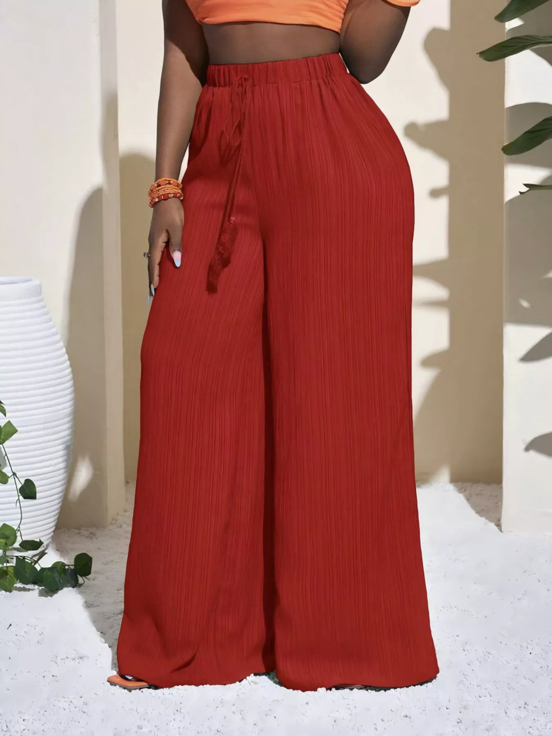 Rust red palazzo pants with tassel drawstring and an extra wide leg