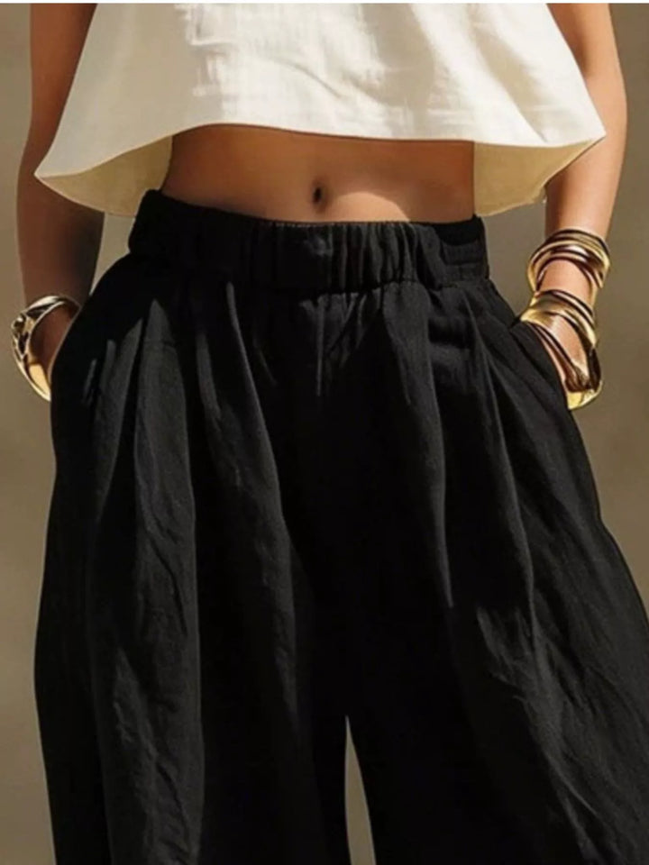 Black palazzo pants waist close-up with elastic waistband and gold bangles