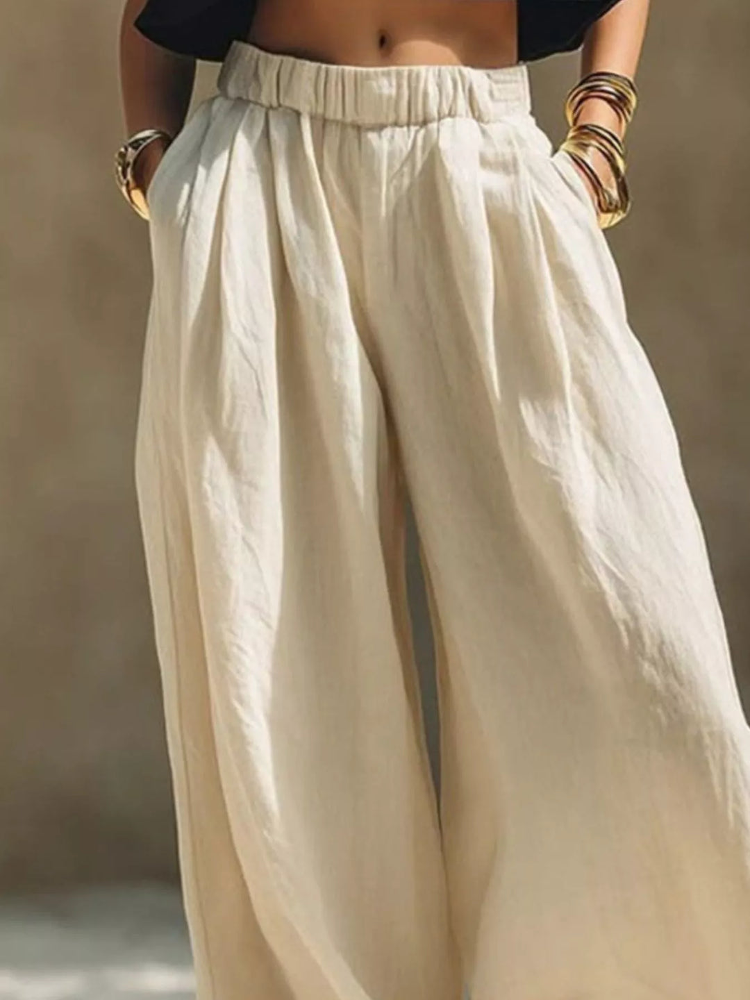 Cream pleated palazzo pants waist detail with elastic band and bracelets