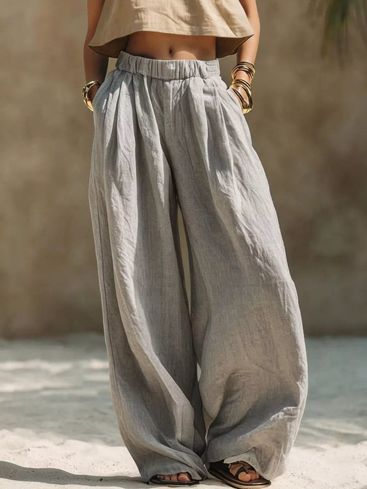 Gray extra wide leg palazzo pants with pleats, worn with a cropped top