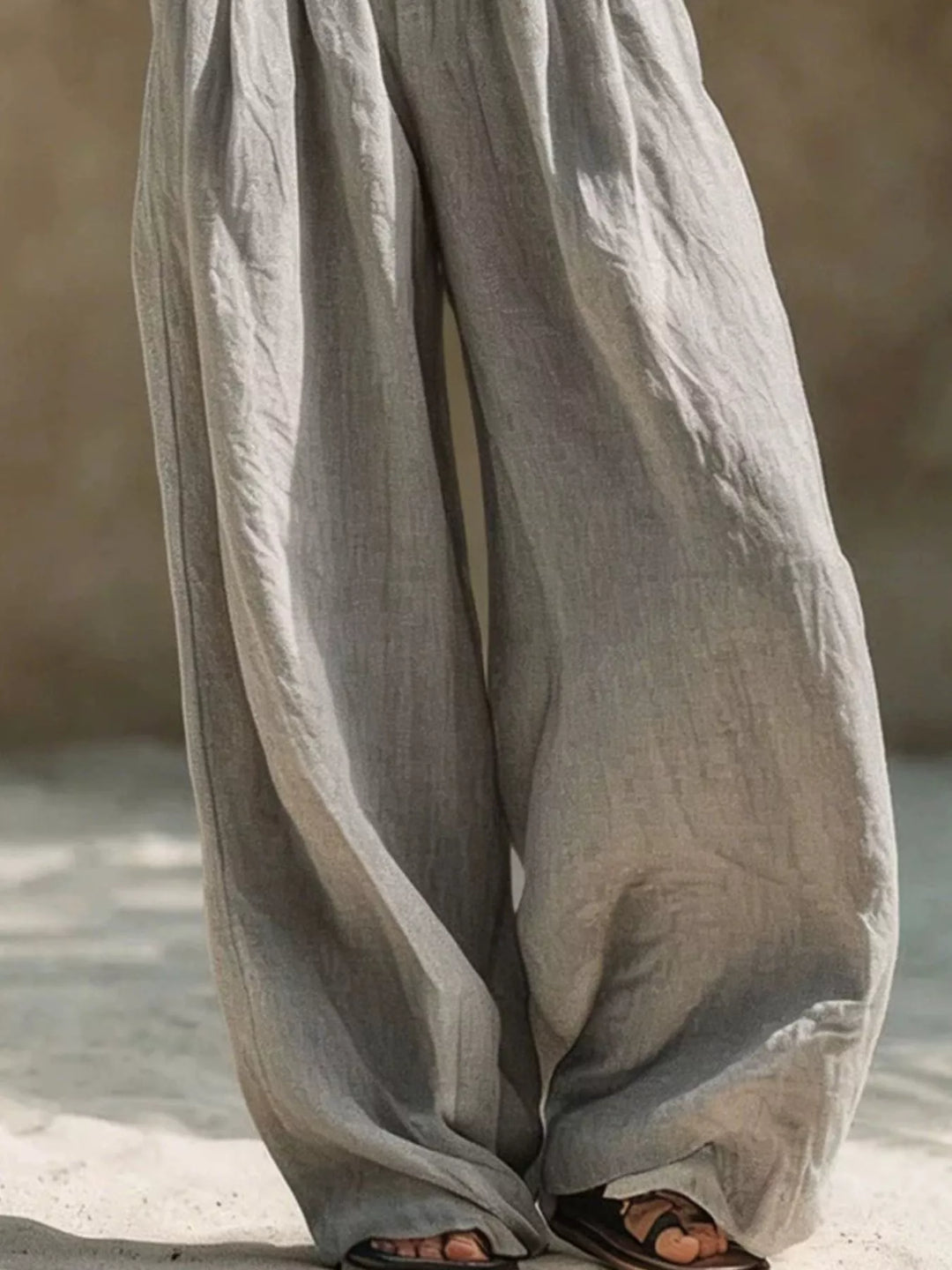 Gray wide leg palazzo pants showing the long relaxed drape toward the hem