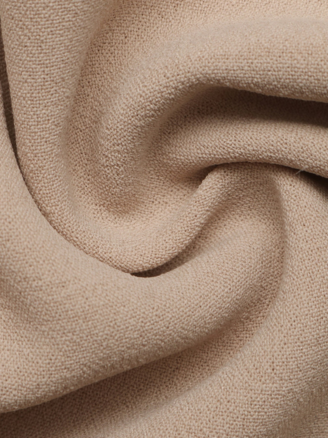 Soft draped fabric folds of the tan wide leg pants