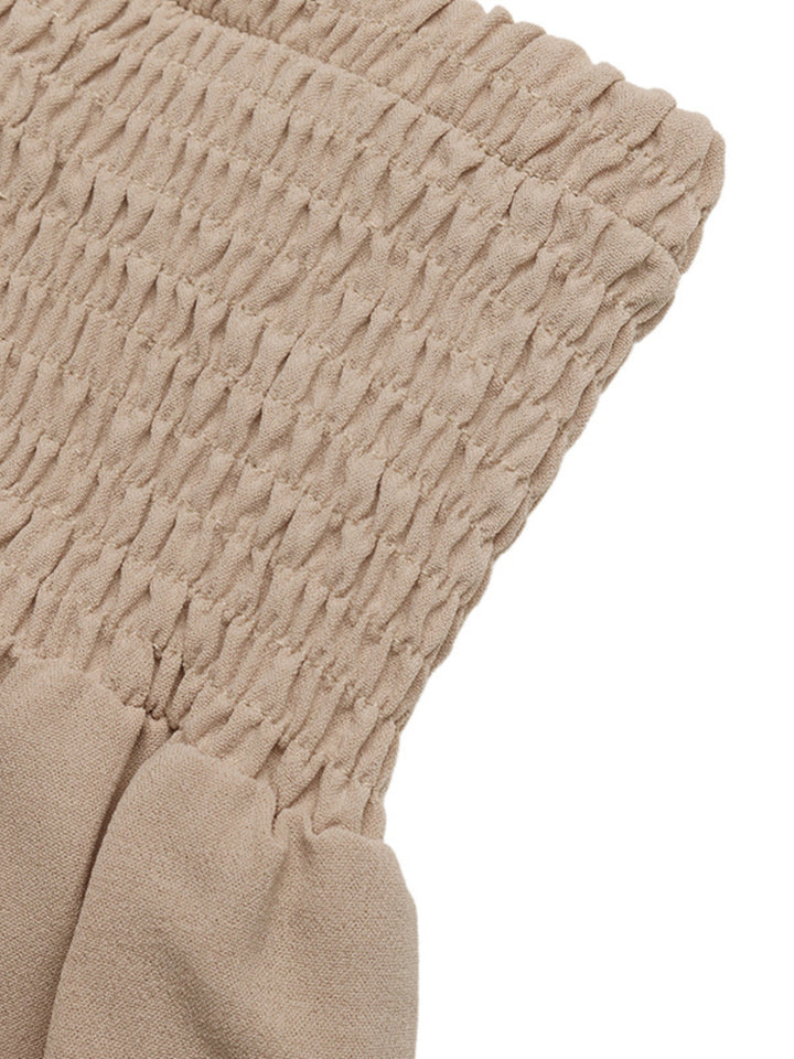Detail of the tan smocked high waist edge laid flat