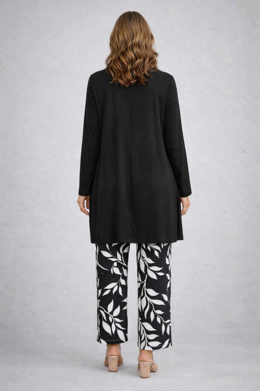 Back view of the long black cardigan over the black and white leaf print pants
