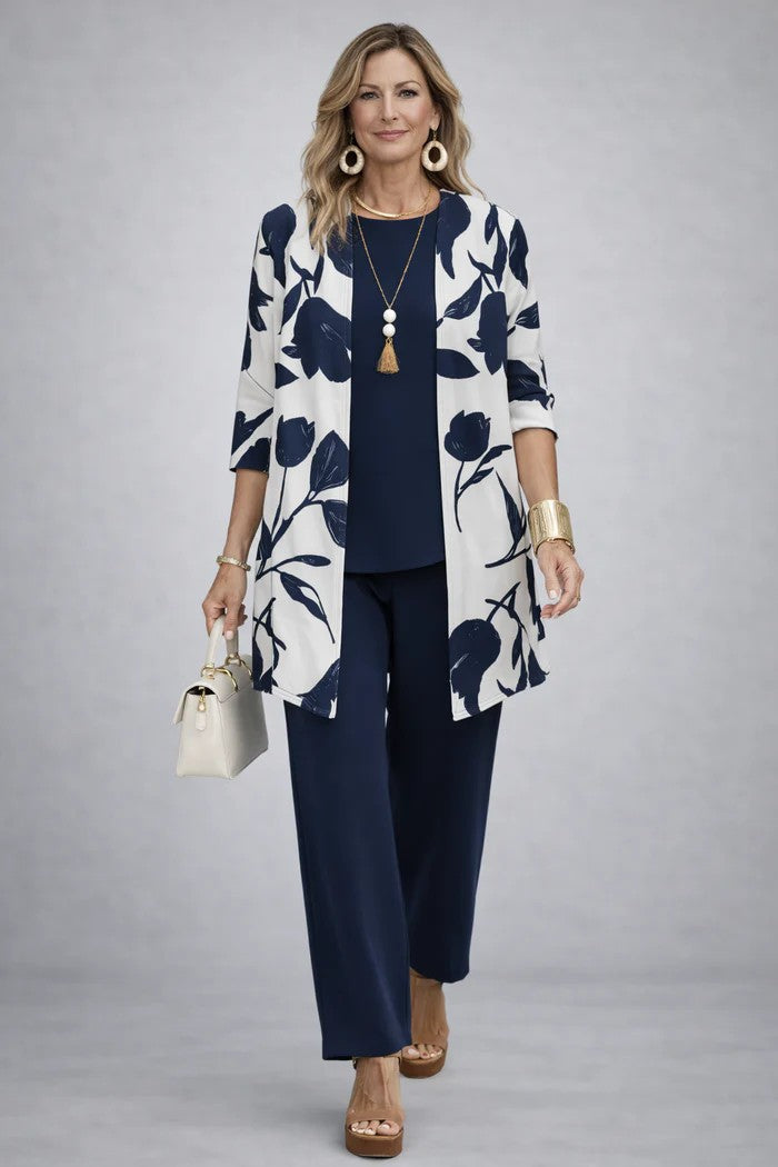 White cardigan with navy floral print worn over a navy top and pants