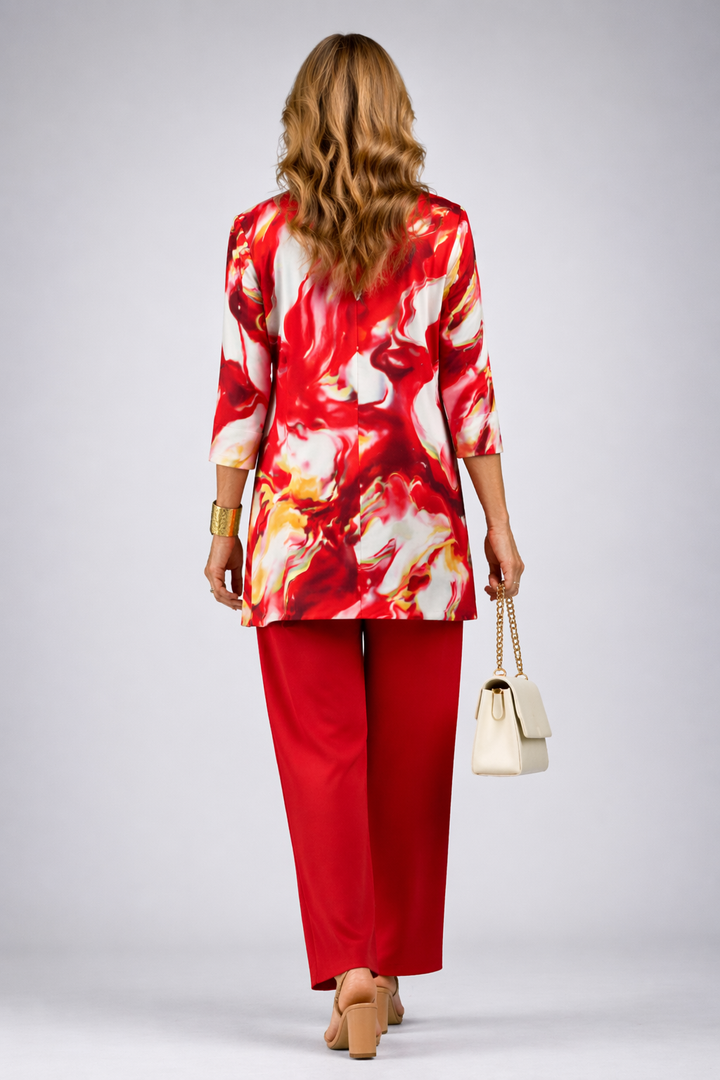 Back view of the red, cream and gold watercolor cardigan over red pants