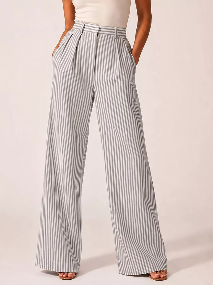 Gray pinstripe pleated wide leg pants, standing front view with hands in pockets