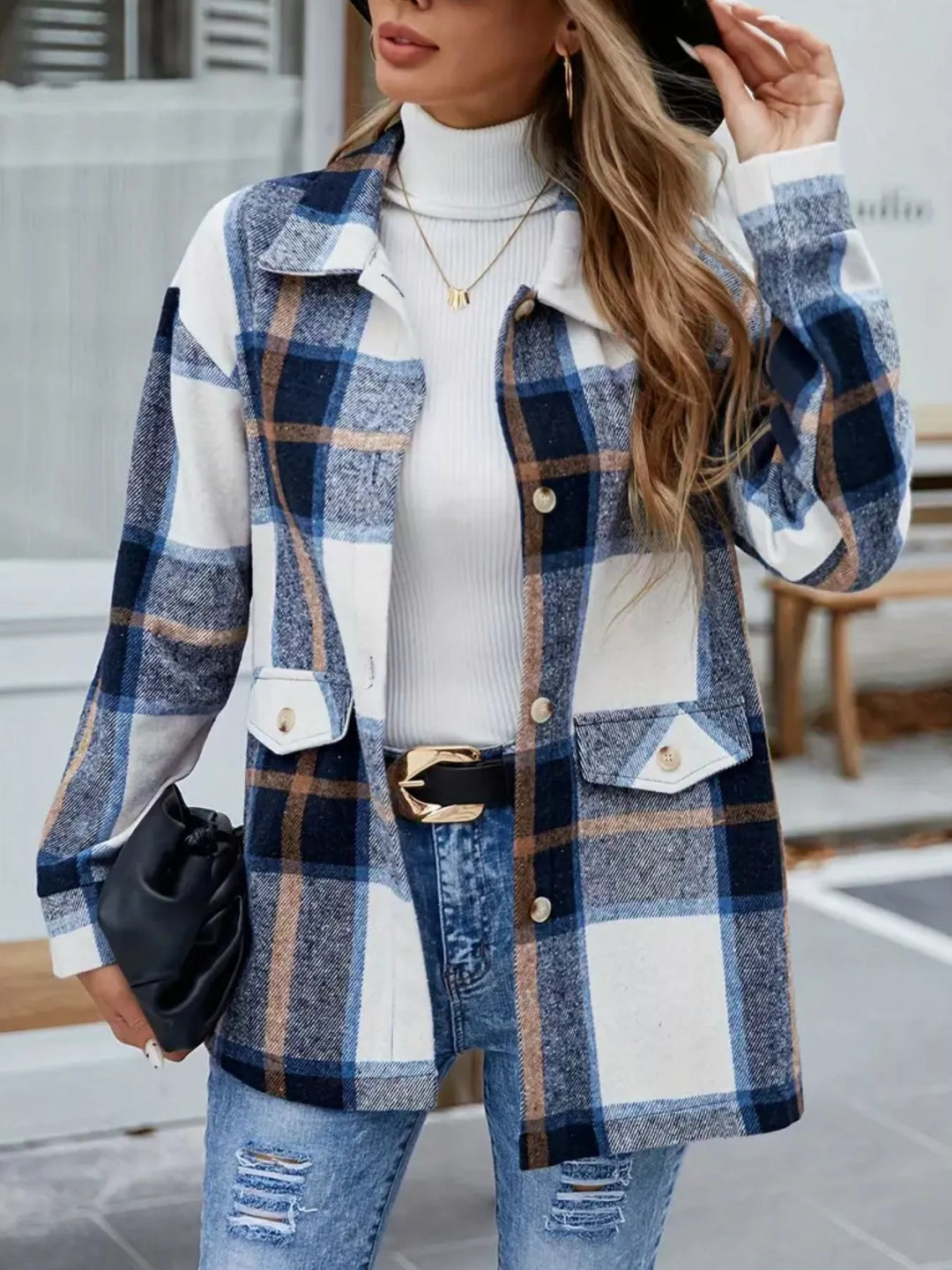 Front view of the navy plaid shacket with chest pockets over a white turtleneck