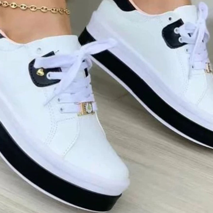 Close-up of white platform sneaker with black sole and heel tab charm