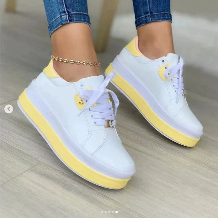 White and yellow platform sneakers with chunky sole worn with an ankle bracelet