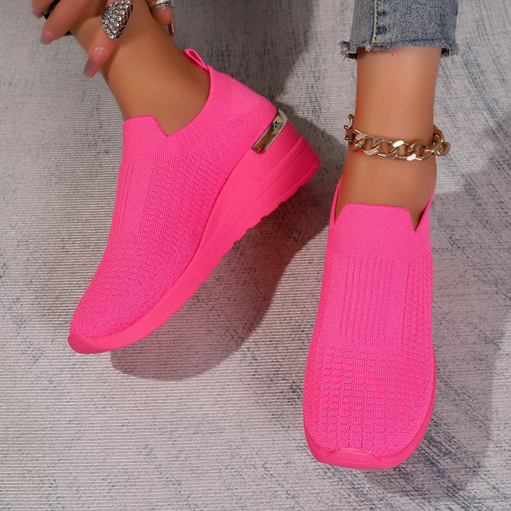 Hot pink slip on platform sneakers with a gold heel accent