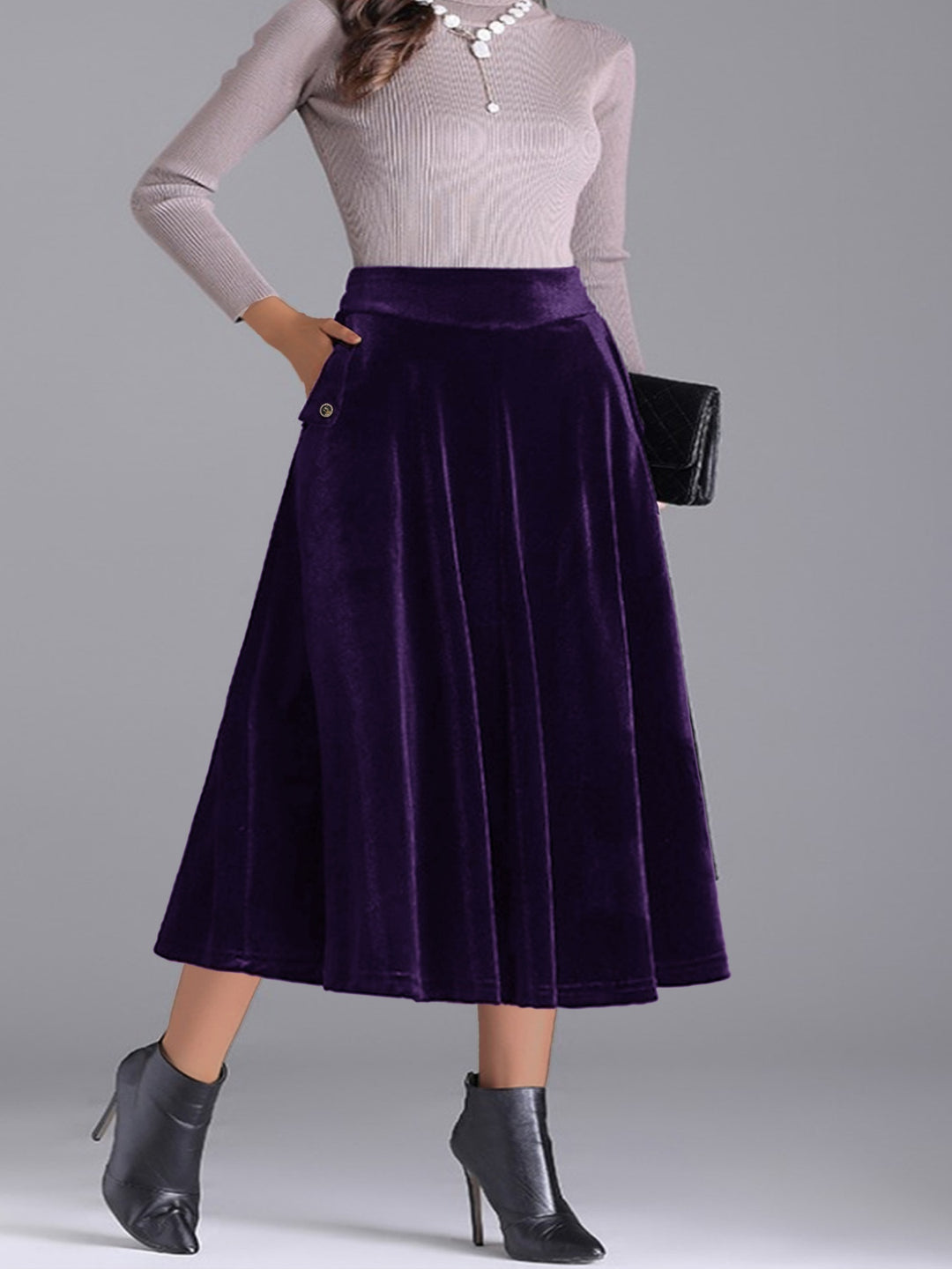 Deep purple pleated skirt styled with a gray sweater and a black clutch