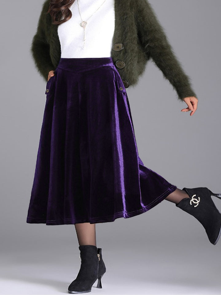 Deep purple velvet-look A line skirt with a white top and green fuzzy cardigan
