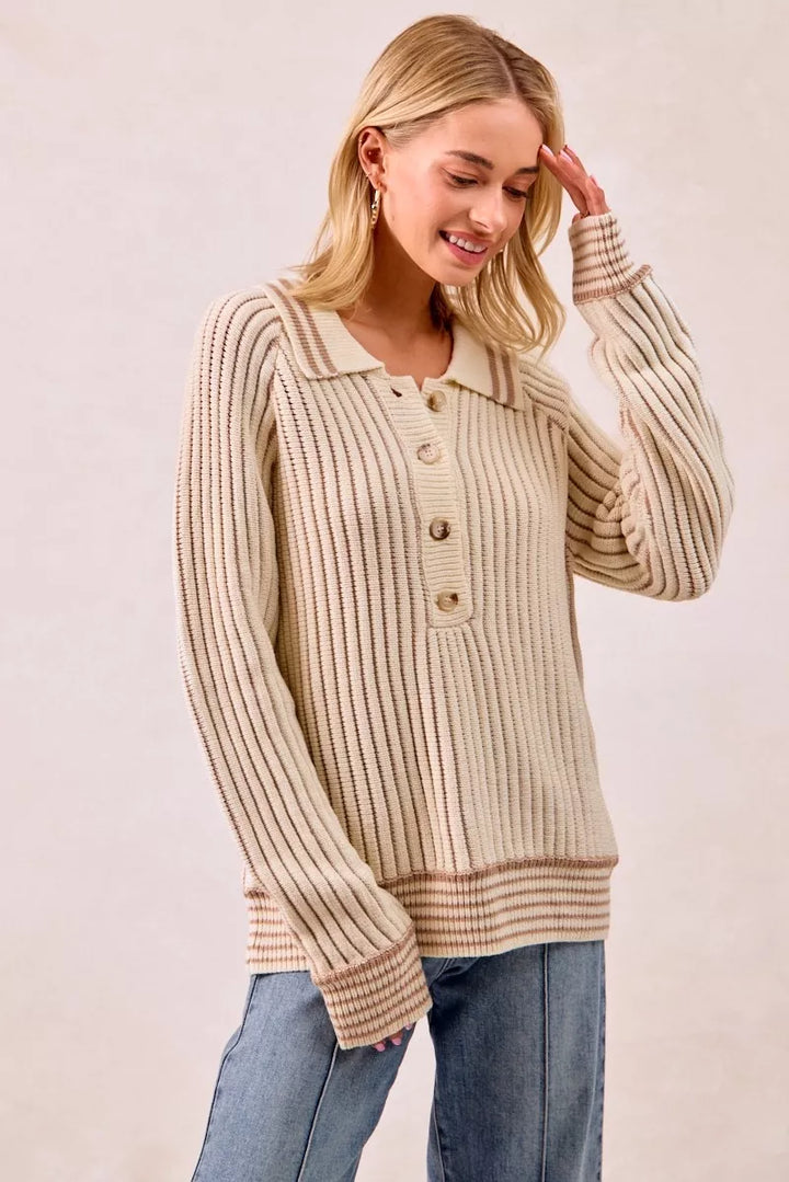 Cream latte half button sweater with hand raised to the head