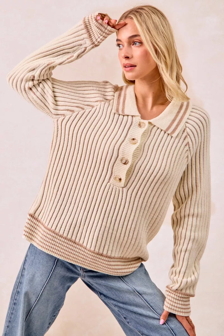 Cream polo sweater with arm raised, showing the relaxed fit and ribbed cuffs