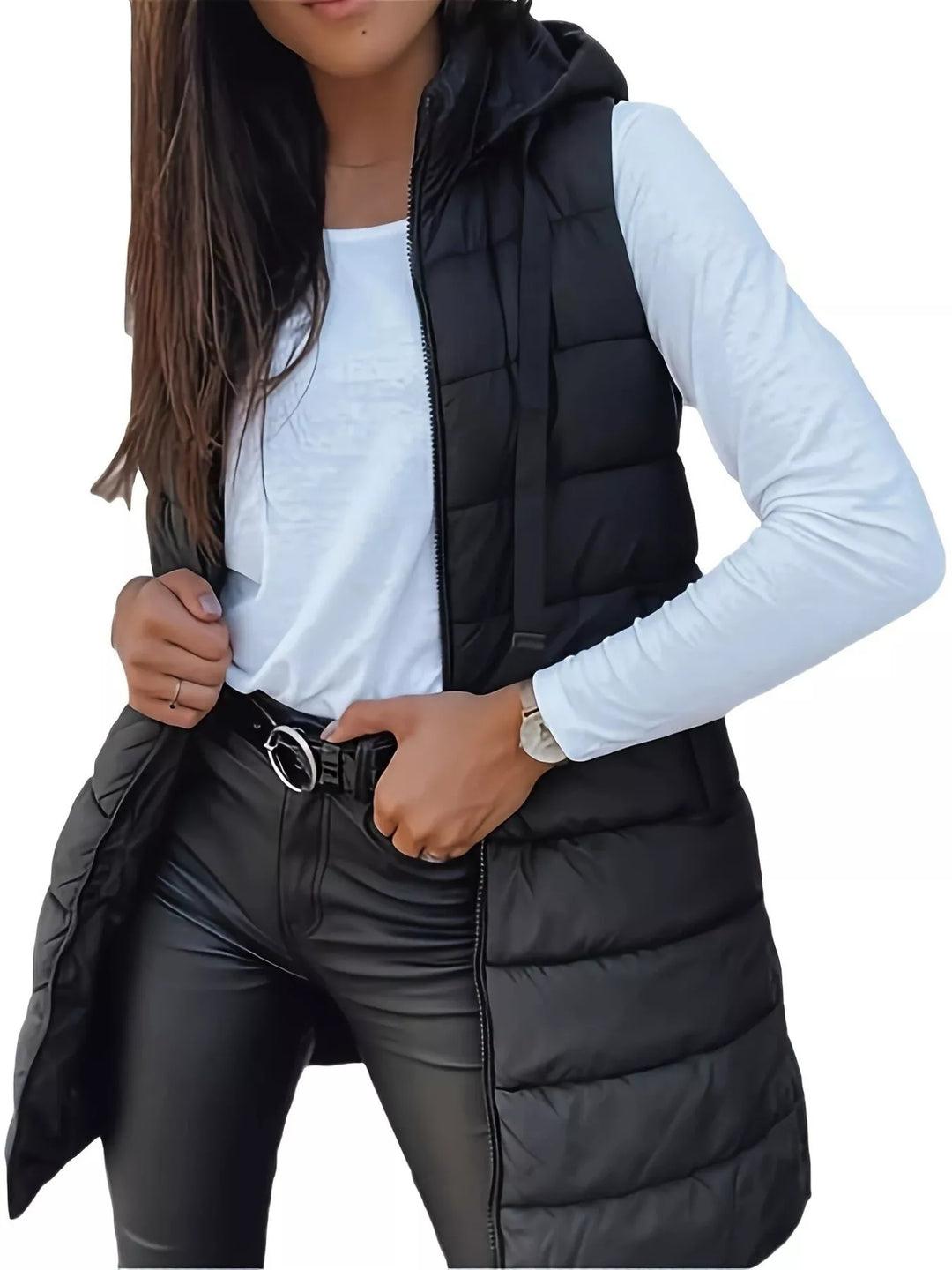 Black longline hooded puffer vest worn open, hands on the belt