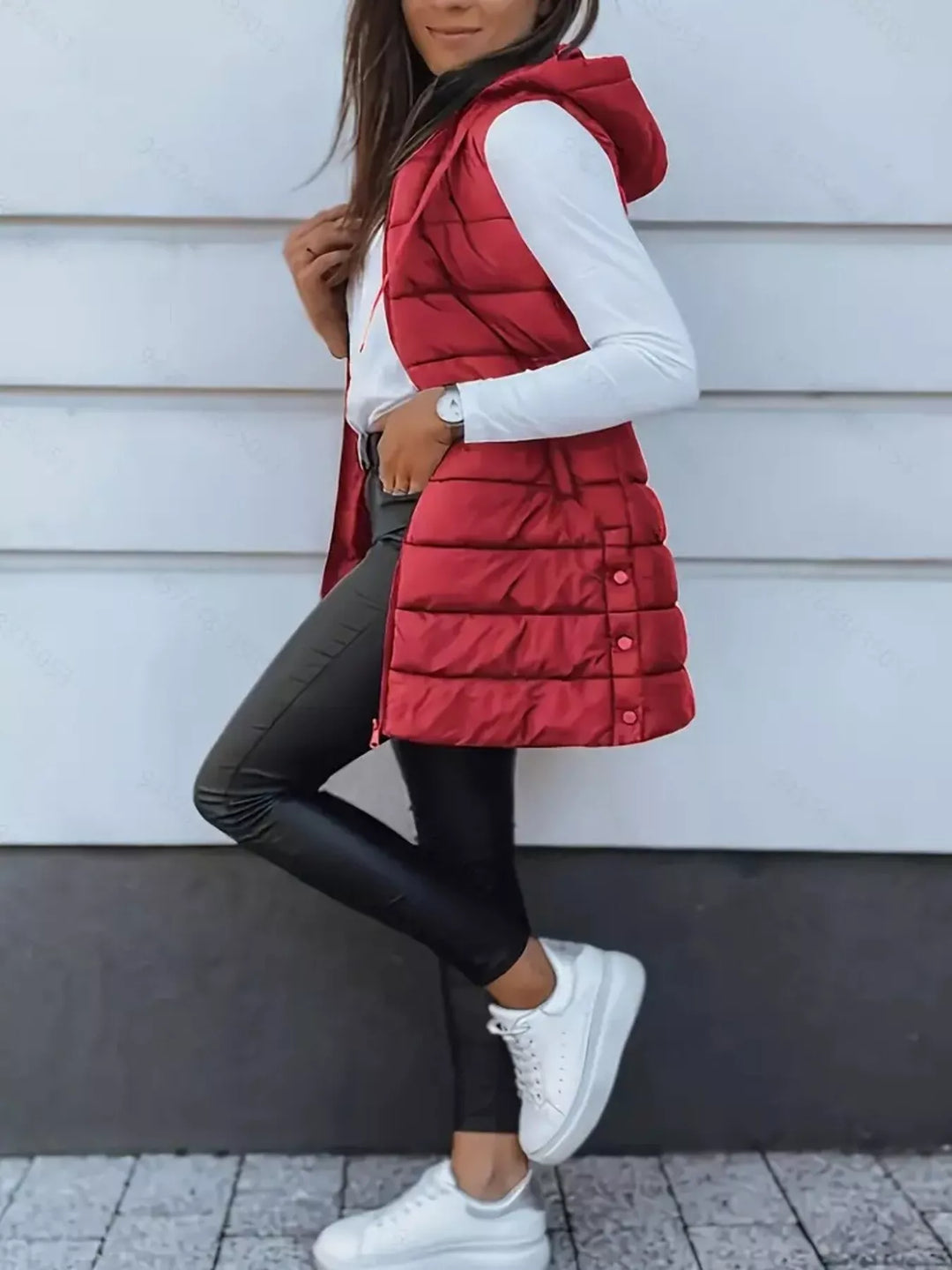 Side pose in the red puffer vest with white sneakers