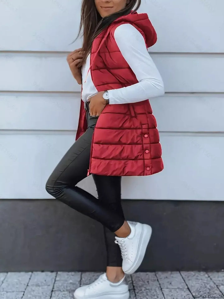 Side pose in the red puffer vest with white sneakers