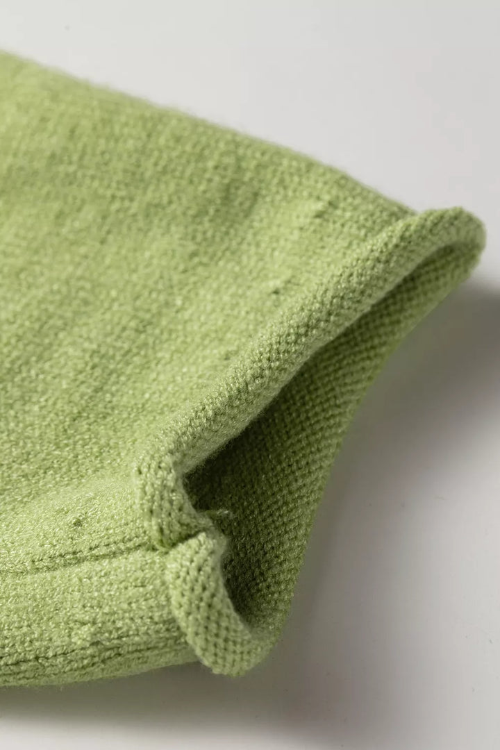 Close-up of the rolled cuff on the pistachio green pullover sweater