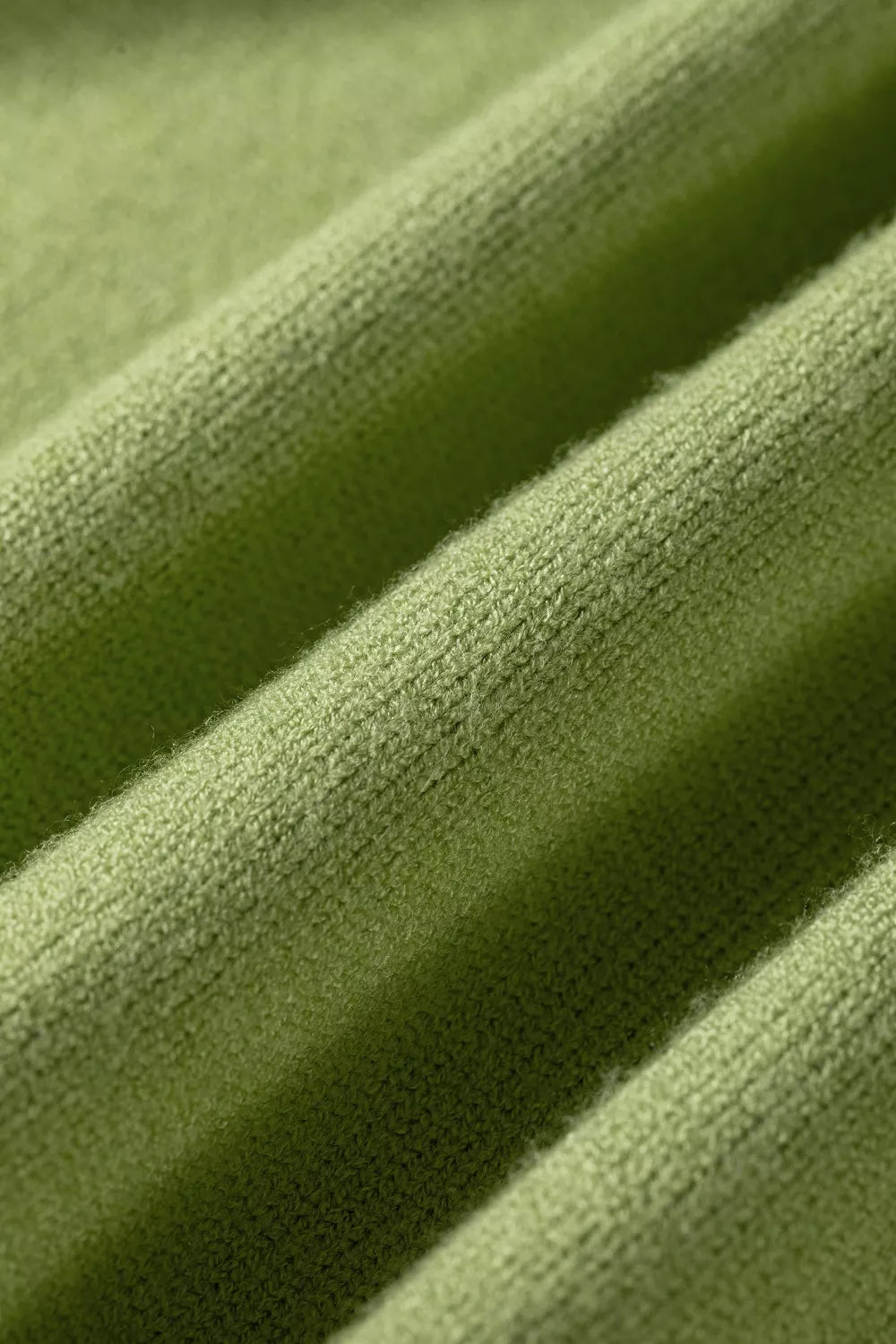 Close-up of the soft knit texture on the pistachio green sweater