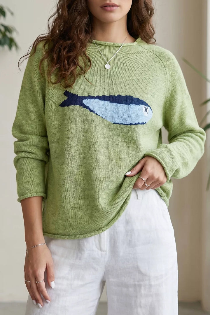 Women's pullover sweater in pistachio green, relaxed crew neck with fish graphic, white pants