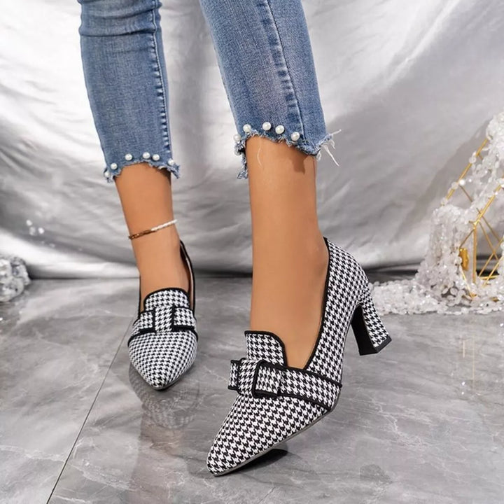 Women's black houndstooth pumps with pointed toe and block heel, worn with cropped jeans
