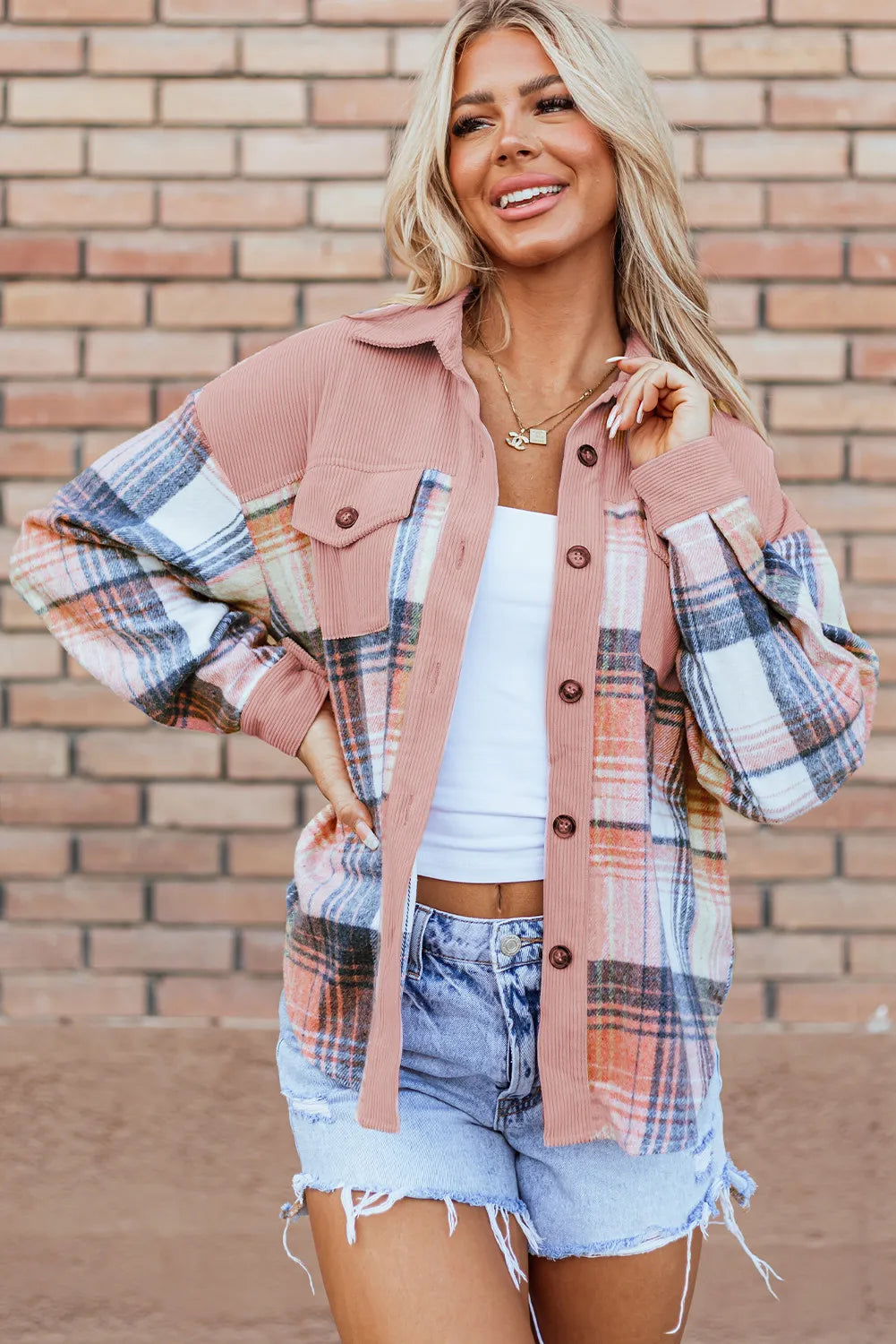 Women's shirt jacket in blush plaid with chest pockets, styled with denim shorts