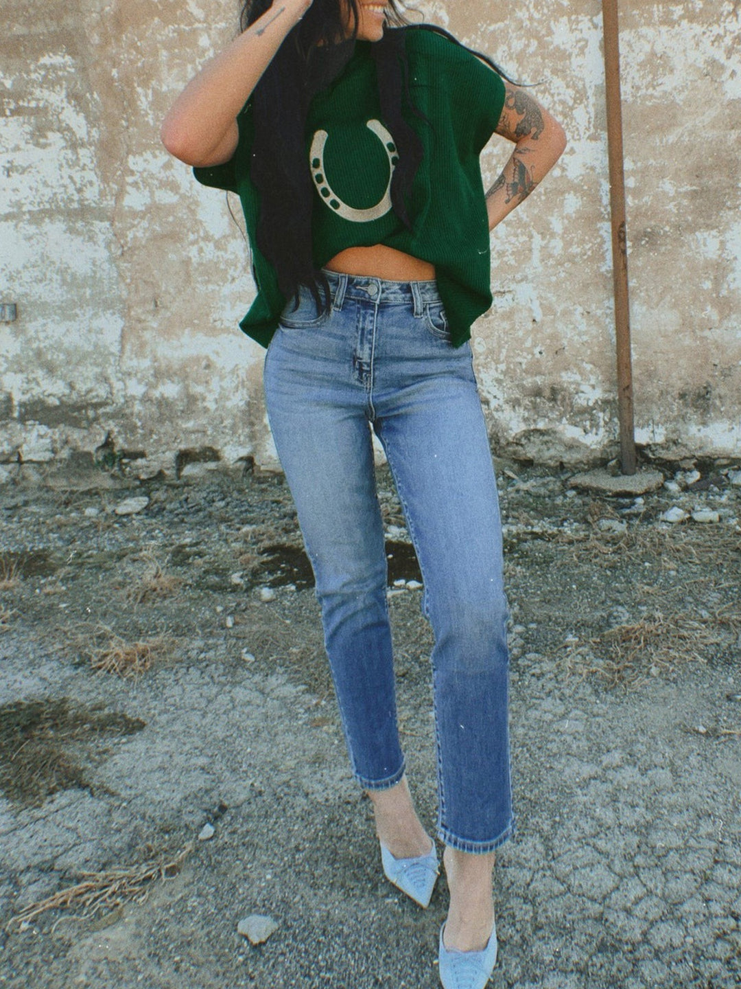 Dark green cropped horseshoe sweater styled with blue jeans and light blue heels