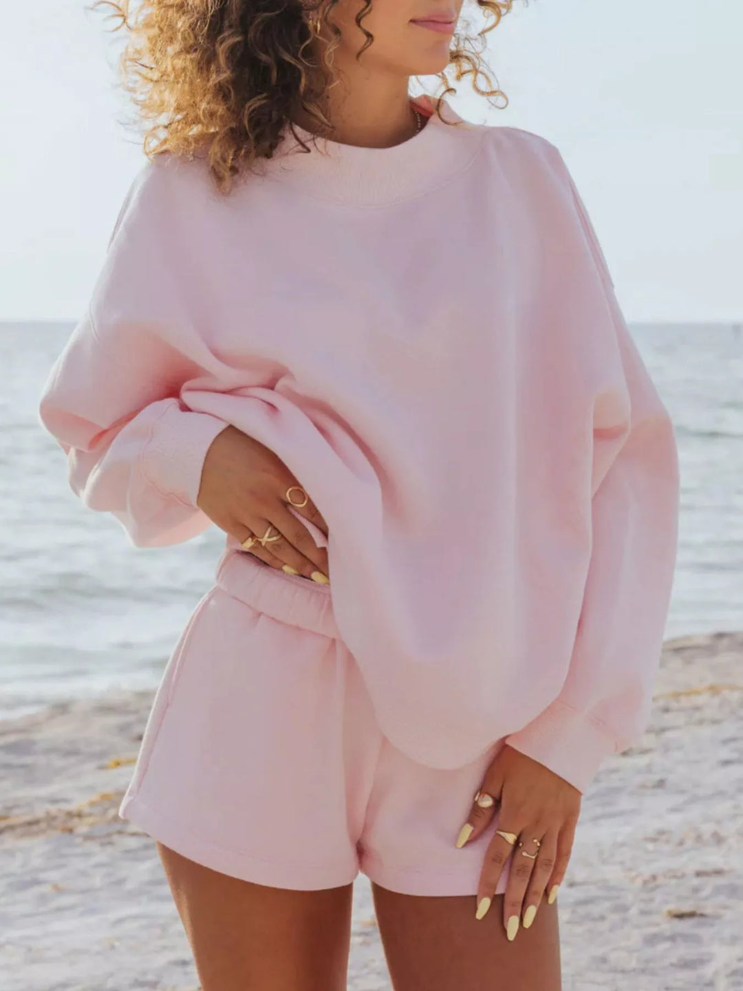 Women's blush pink shorts set, oversized fleece-look sweatshirt and shorts, on the beach