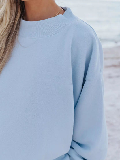 Detail of the sky blue sweatshirt crew neckline and drop shoulder sleeve