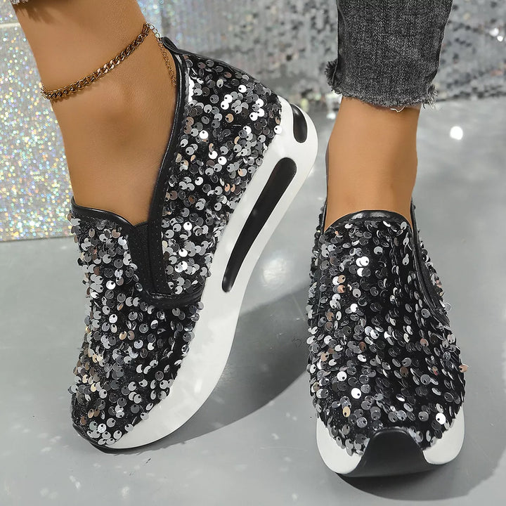 Women's slip on sneakers with sequin platform in black, worn with gray jeans