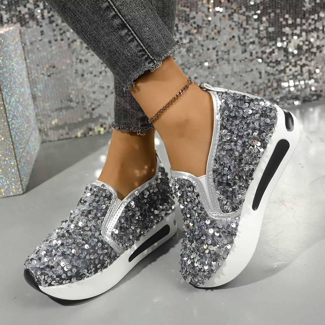 Grey sequin platform slip on sneakers worn with ankle jewelry and jeans