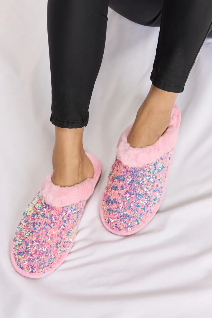 Pink sequin slip on slippers with plush trim, front view of the pair