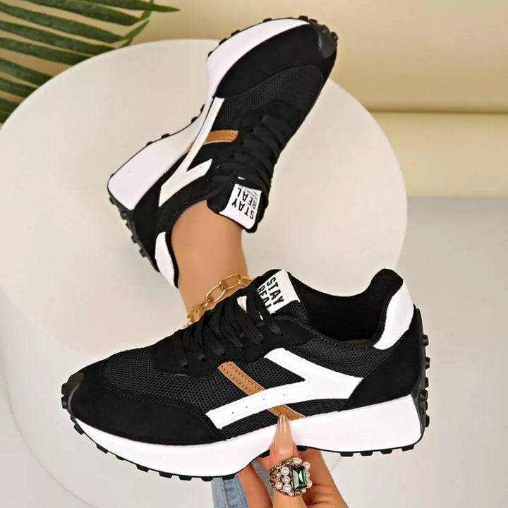 Black brown chunky sneakers with white accent shown from the side and heel