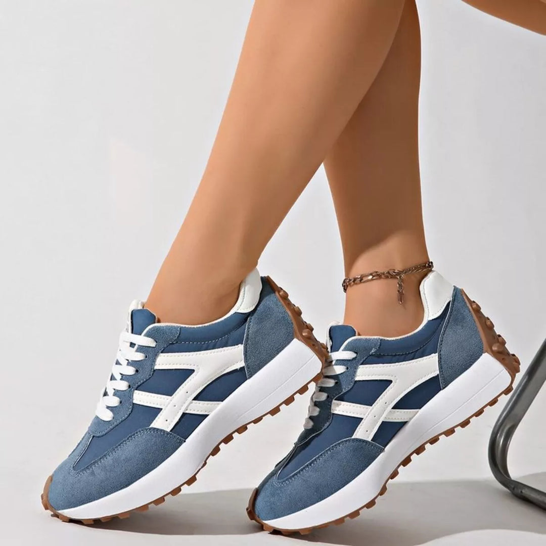 Denim blue chunky platform sneakers with white accent, worn on feet