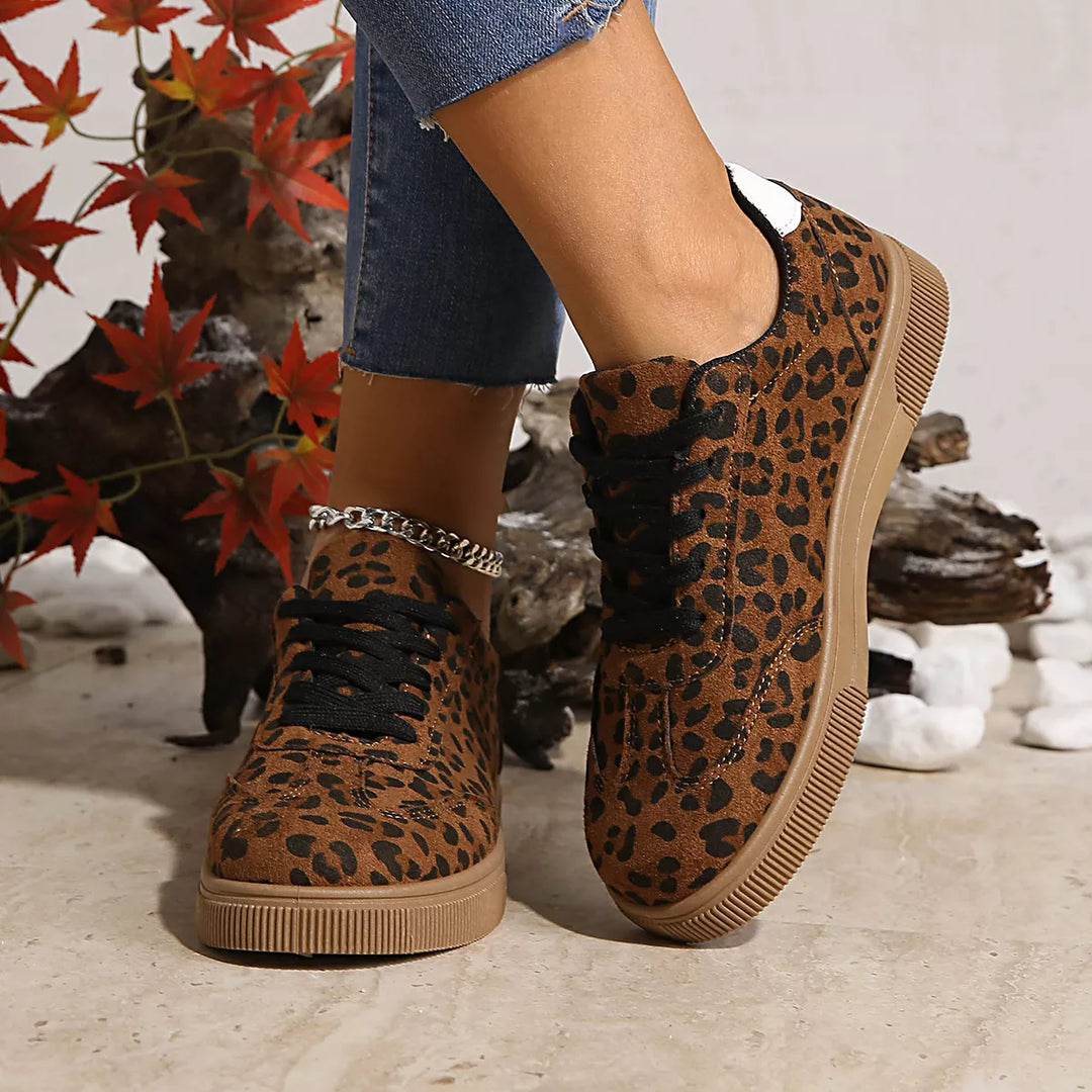 Front angle of leopard print lace up sneakers with black laces on feet