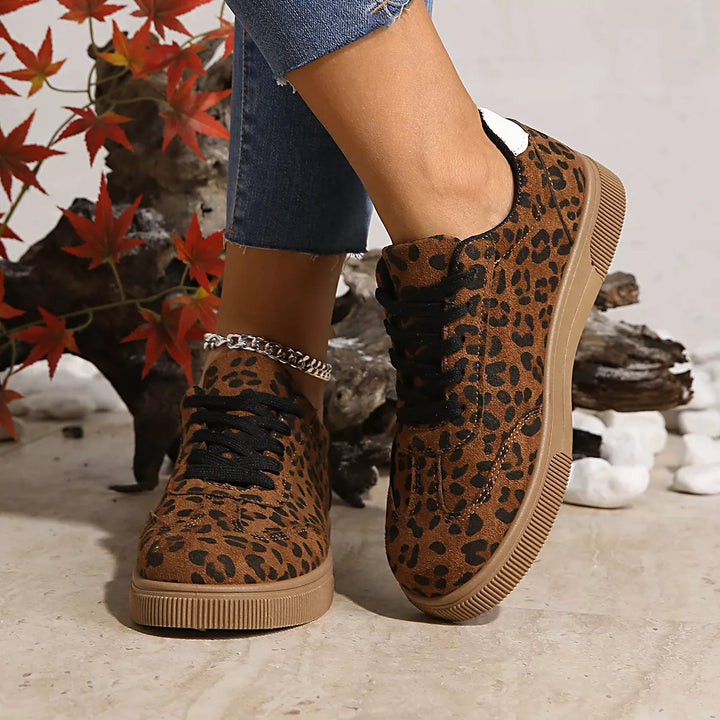Front angle of leopard print lace up sneakers with black laces on feet