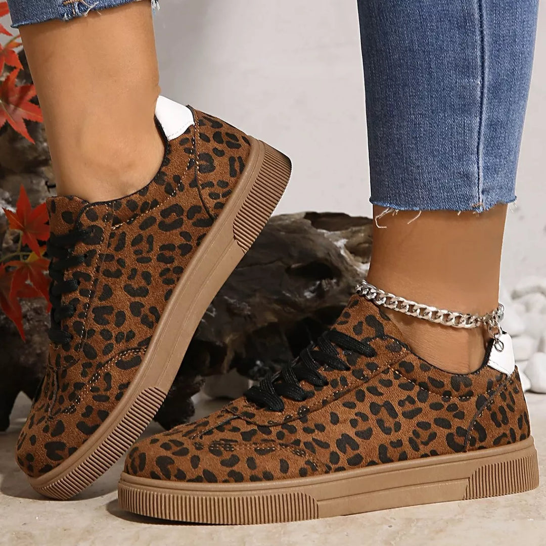 Leopard print low top sneakers worn with frayed hem jeans and an ankle chain