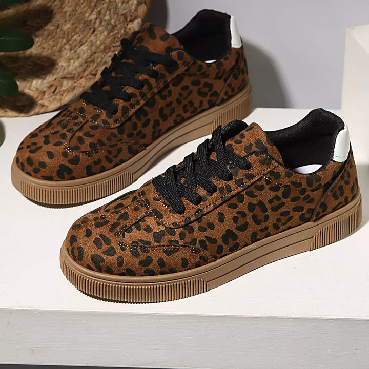 Women's sneakers, low top leopard print lace up pair on a white surface