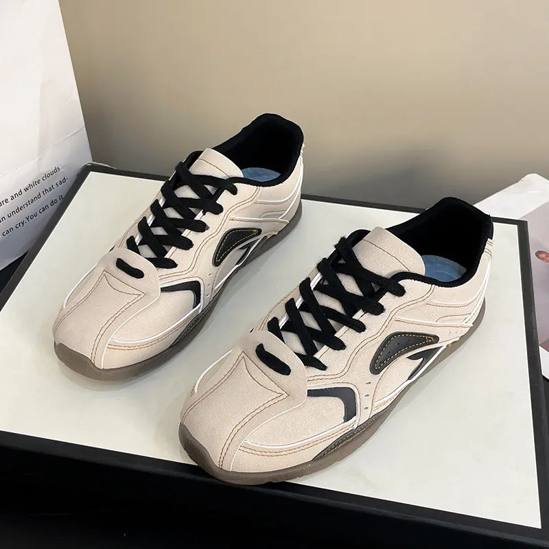Pair of cream black retro sneakers with black laces on a white display box