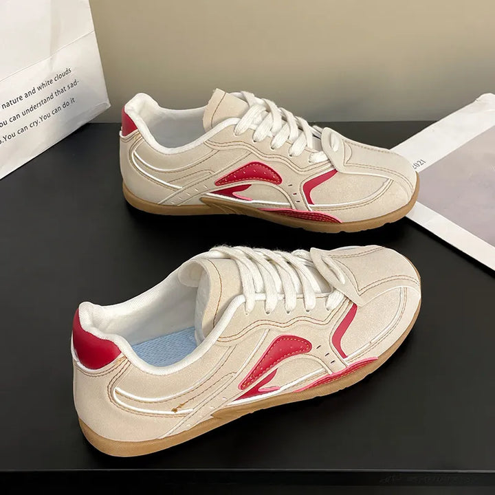 Pair of cream and red contrast panel sneakers, top and side views