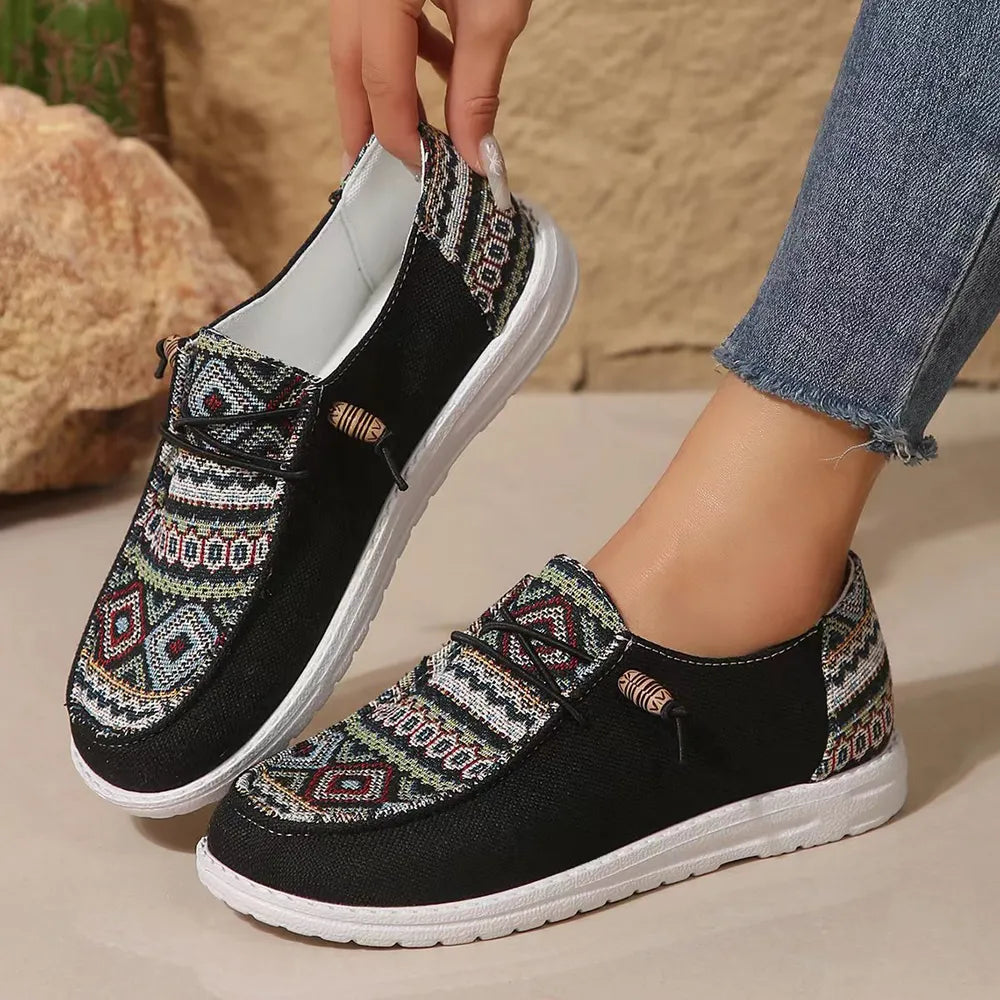 Women's black Aztec print slip on sneakers worn with cuffed jeans