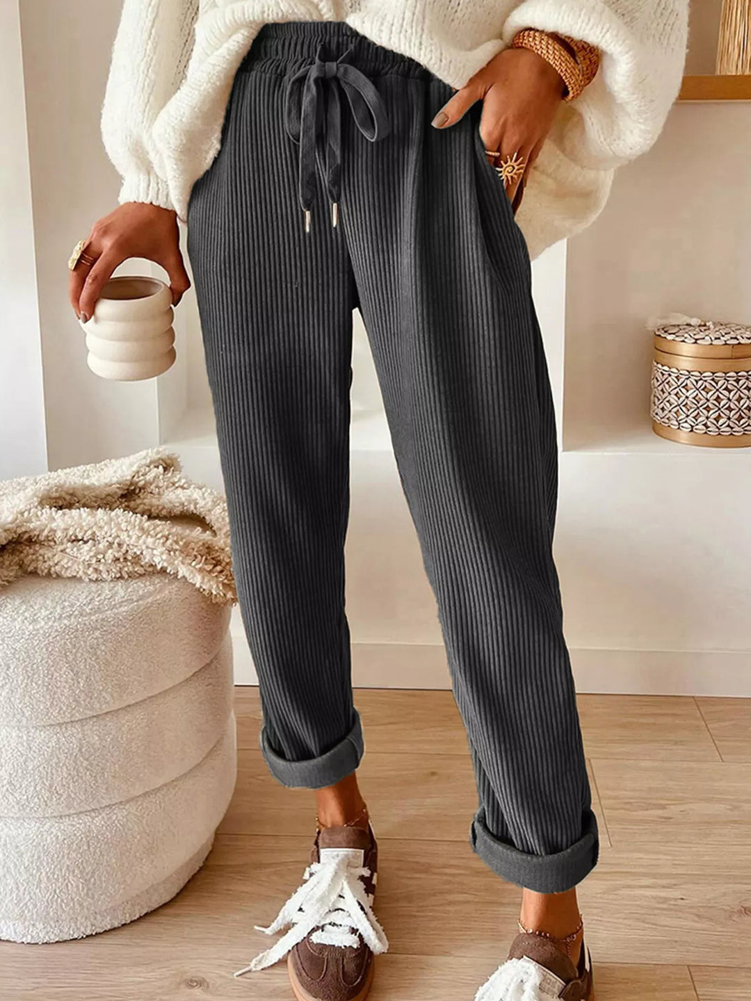 Charcoal ribbed straight leg pants with drawstring, worn with a cream sweater
