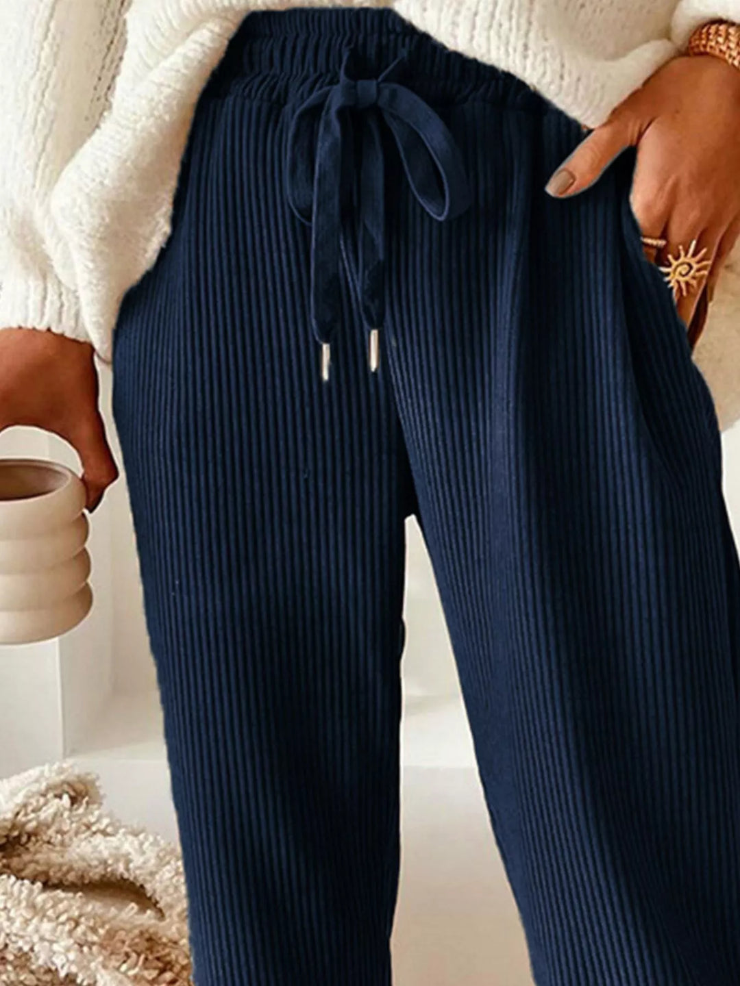 Close-up of the navy ribbed drawstring waist with hand in pocket
