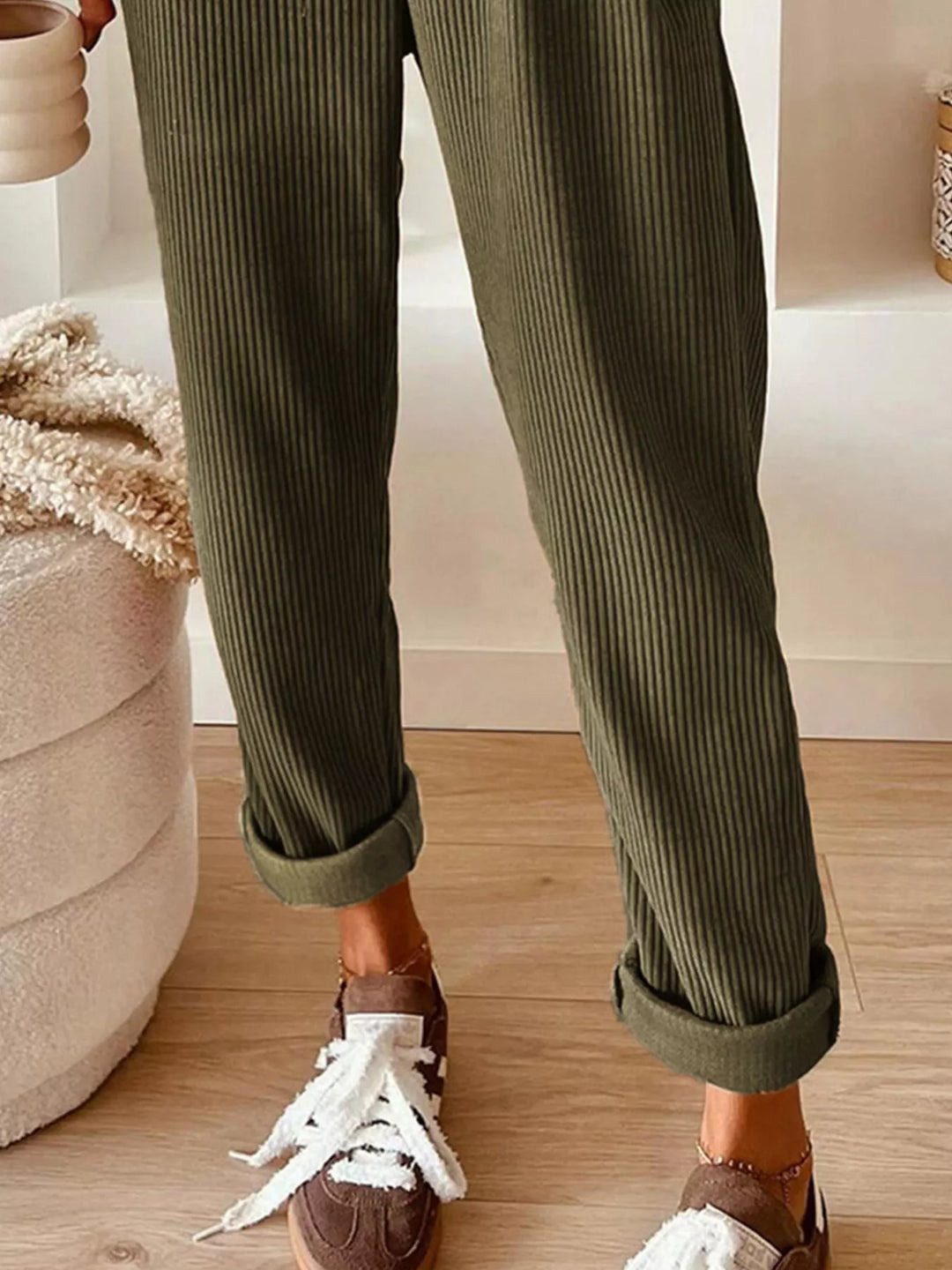 Olive cuffed ankle straight leg pants paired with white sneakers