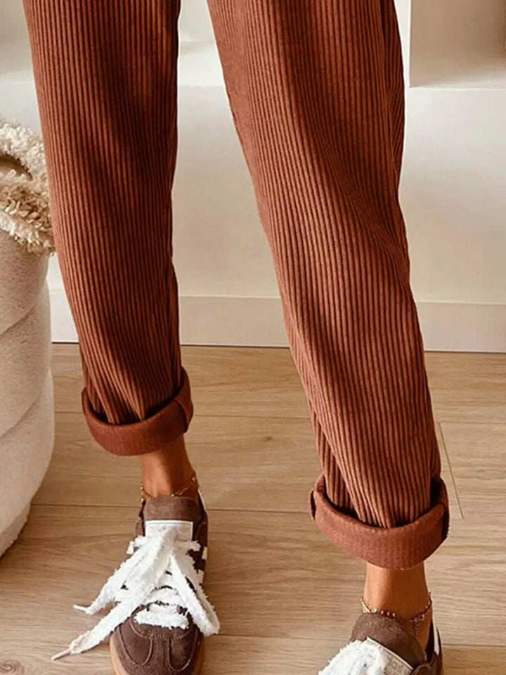 Rust ribbed straight leg pants with cuffed ankle and white sneakers