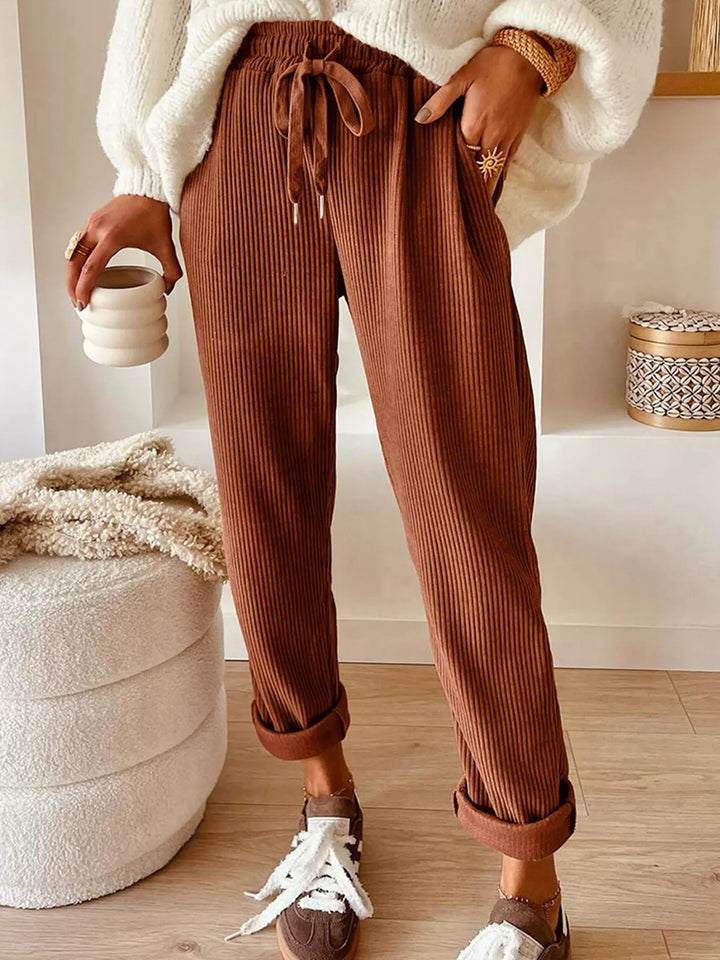Women's straight leg pants in rust, ribbed drawstring cuffed ankle, worn with a cream sweater