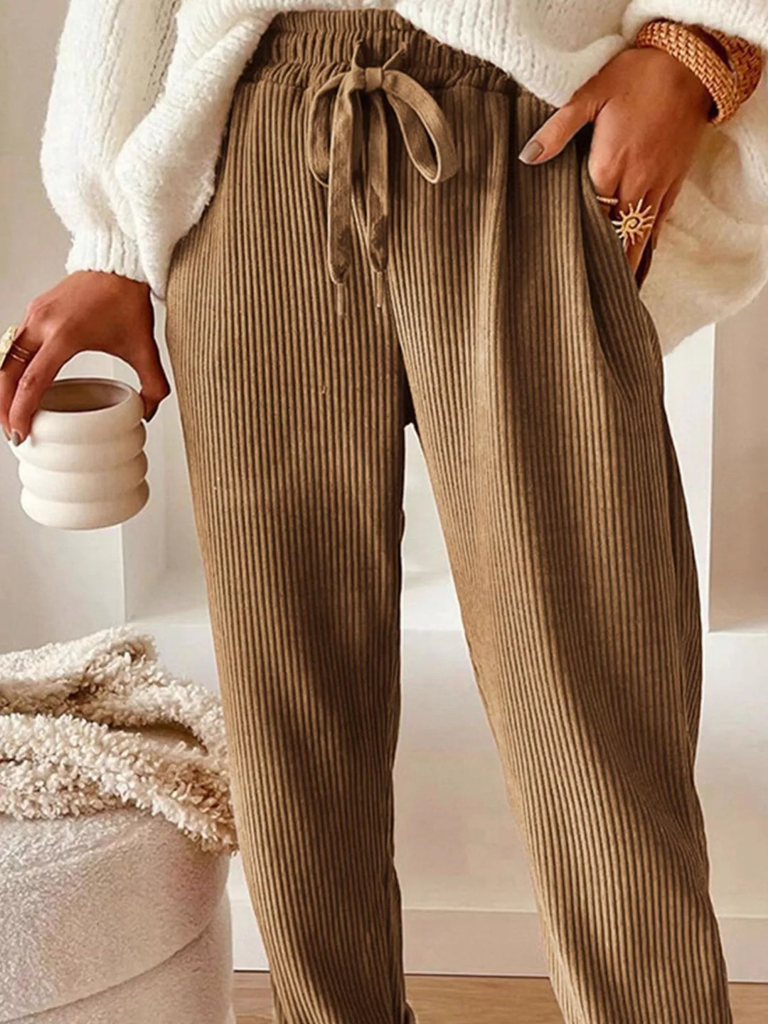 Close-up of the tan ribbed pants tied waist and side pocket