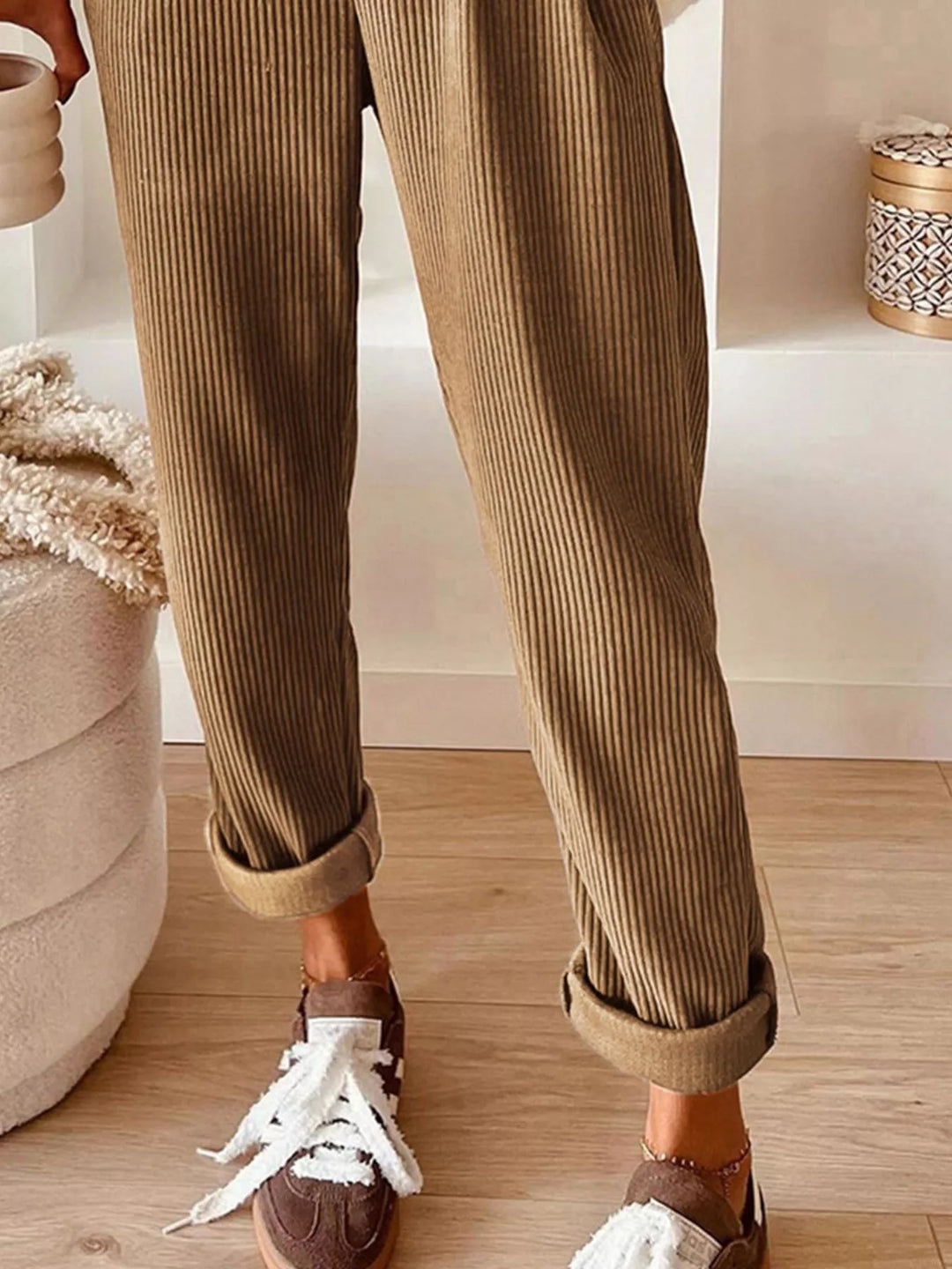 Tan straight leg pants with cuffed ankle shown with white sneakers