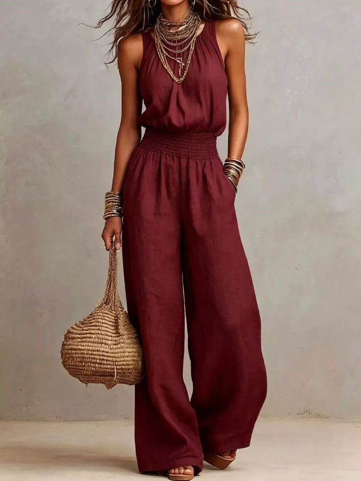 Burgundy summer jumpsuit with halter neck and wide leg, standing pose